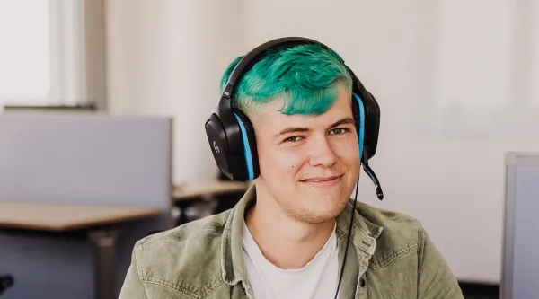 CGI Mitarbeiter mit Kopfhörer im grünen Haaren